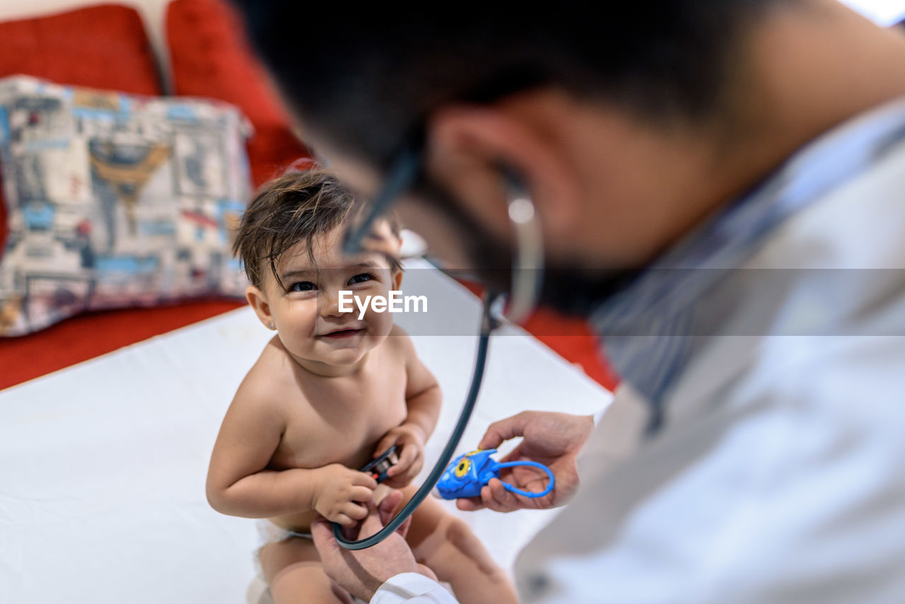 Doctor observing a one-year-old baby