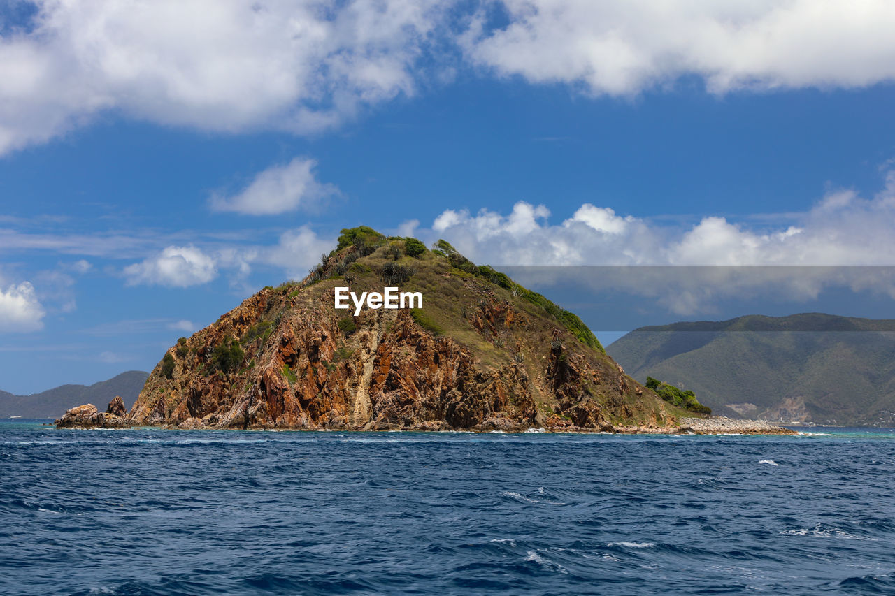 Scenic view of sea and mountains against sky