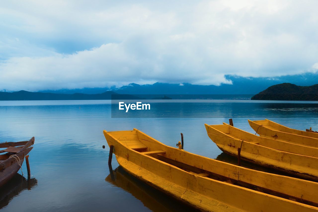 Boats moored in sea against sky