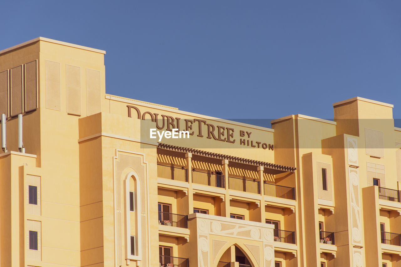 LOW ANGLE VIEW OF BUILDINGS AGAINST BLUE SKY