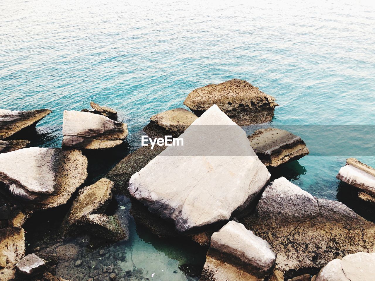 HIGH ANGLE VIEW OF ROCKS ON SHORE