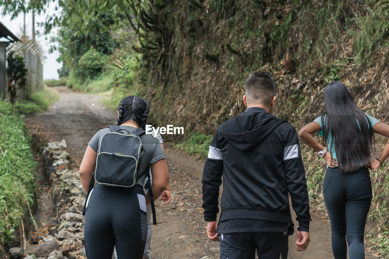 Young latinos hiking through the colombian mountains, on dirt roads and desolate trails.