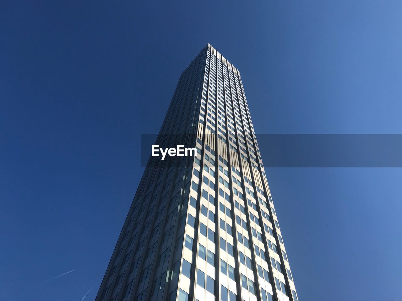 LOW ANGLE VIEW OF MODERN BUILDING AGAINST BLUE SKY