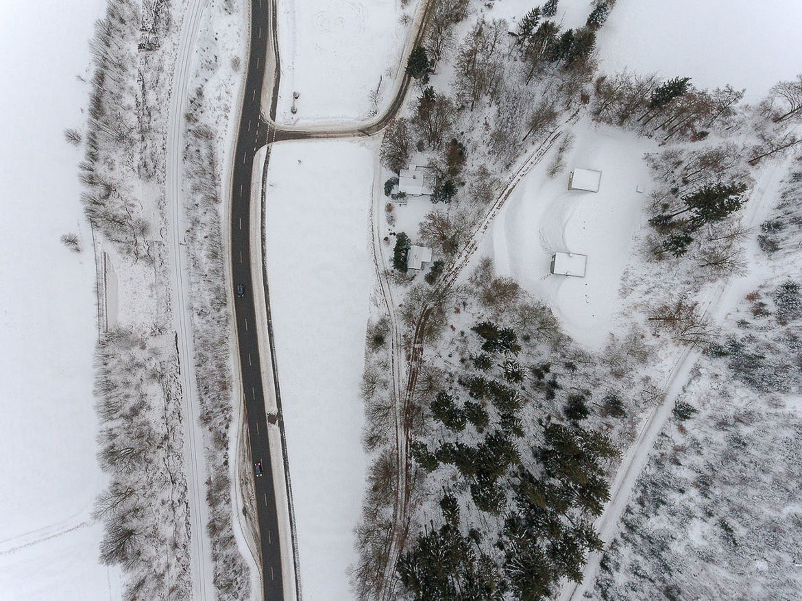 Snow covered road by trees