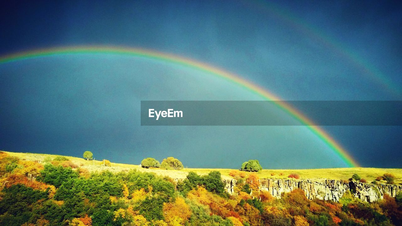 SCENIC VIEW OF RAINBOW OVER MOUNTAINS AGAINST SKY