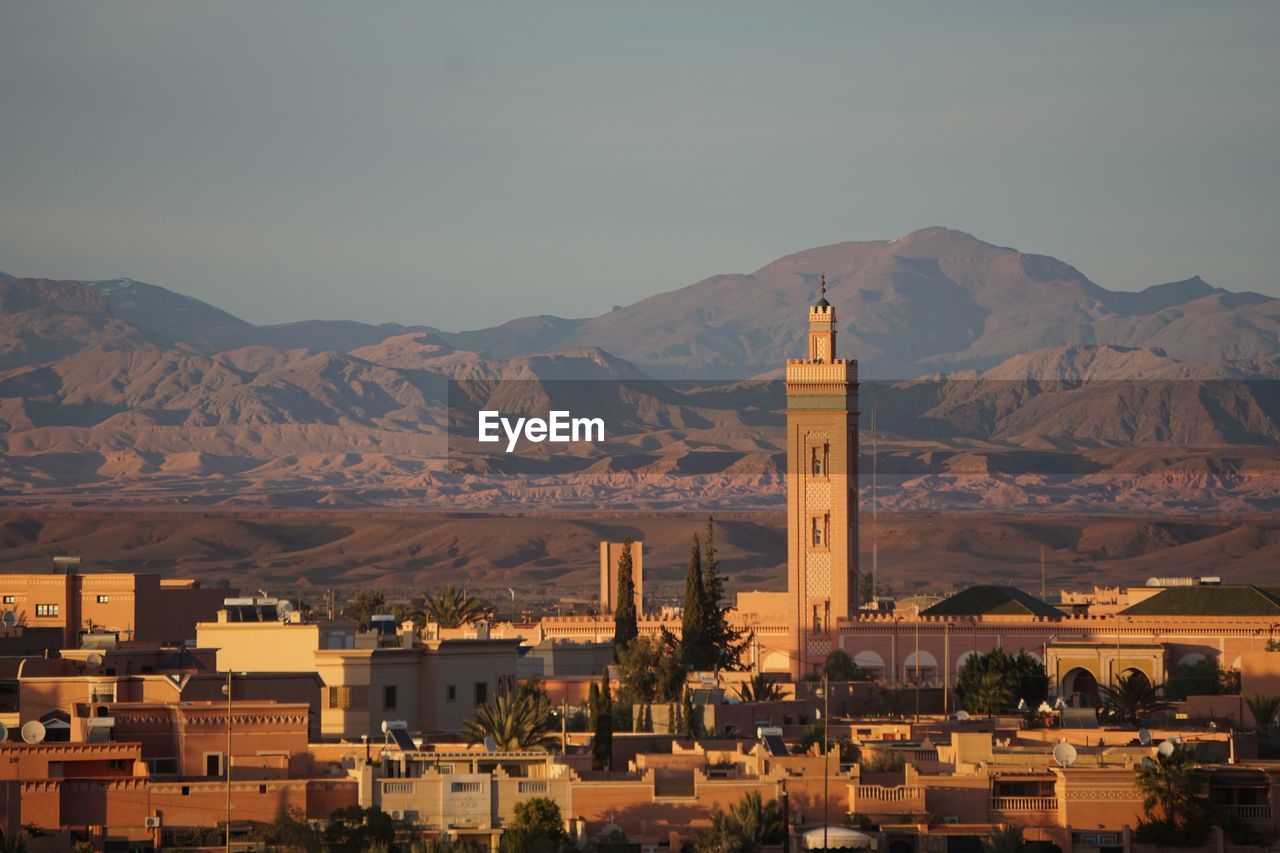 View of town by mountain against sky