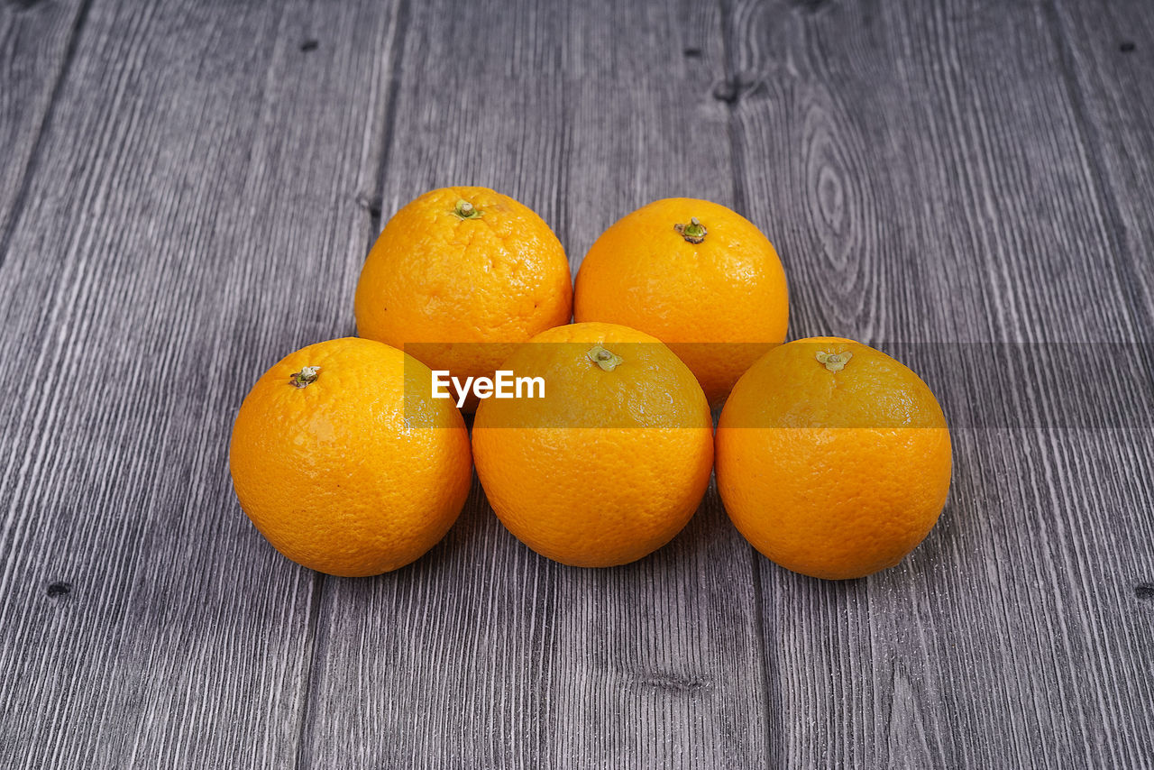 CLOSE-UP OF ORANGES ON TABLE