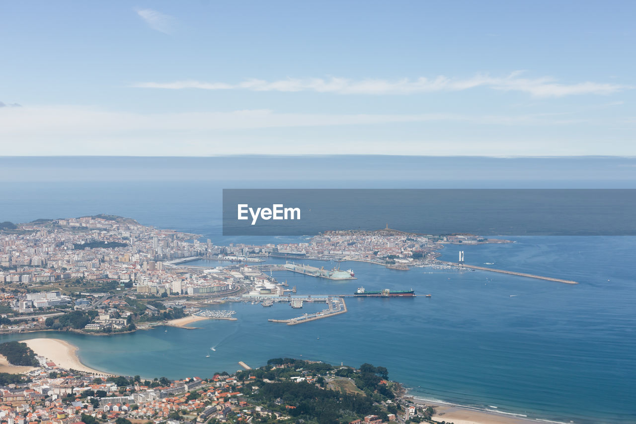 High angle view of cityscape by sea against sky