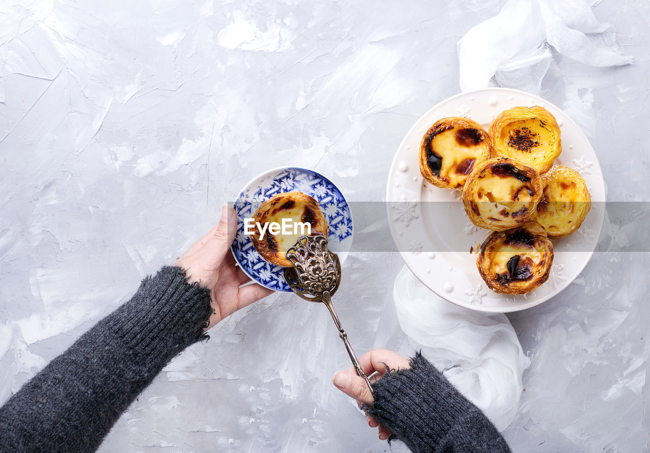 Cropped hands taking food in plate