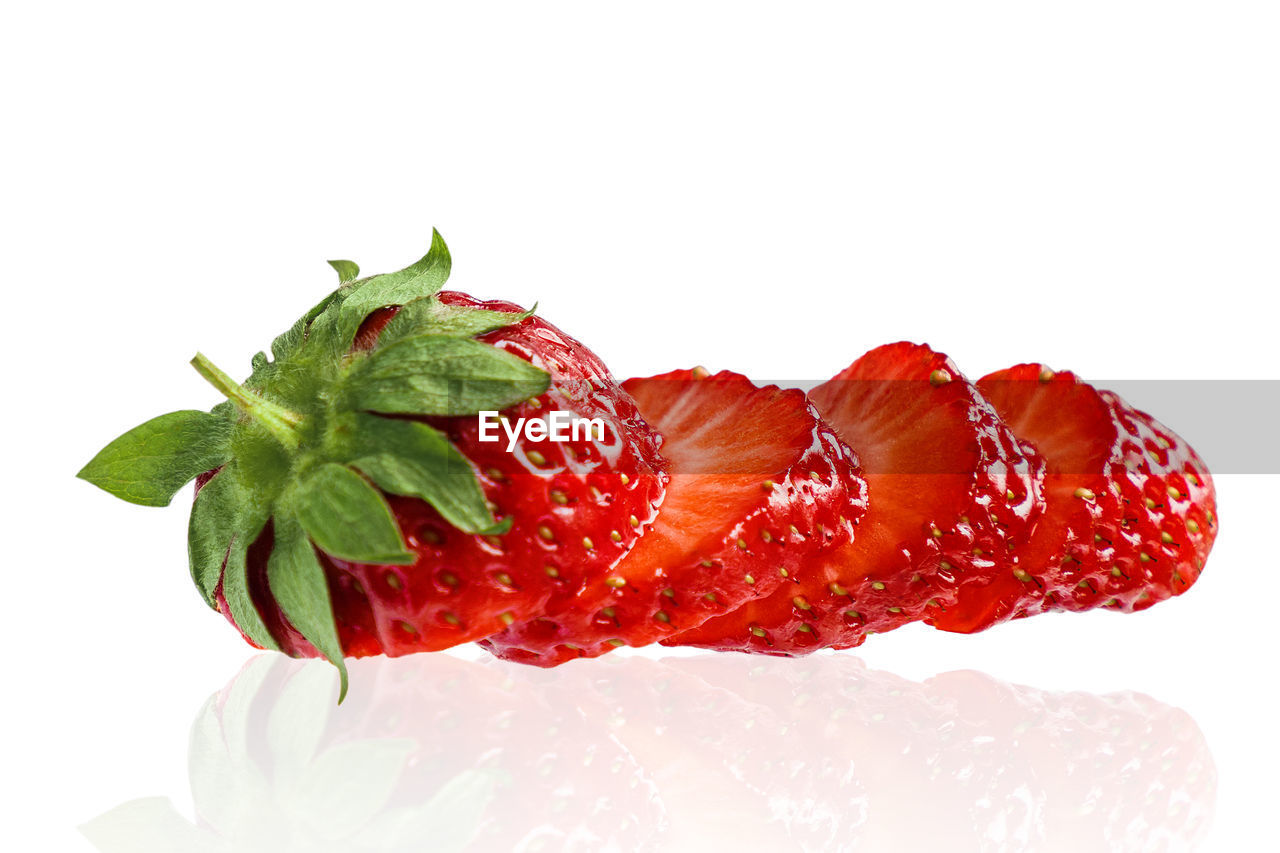 CLOSE-UP OF RED FRUIT OVER WHITE BACKGROUND