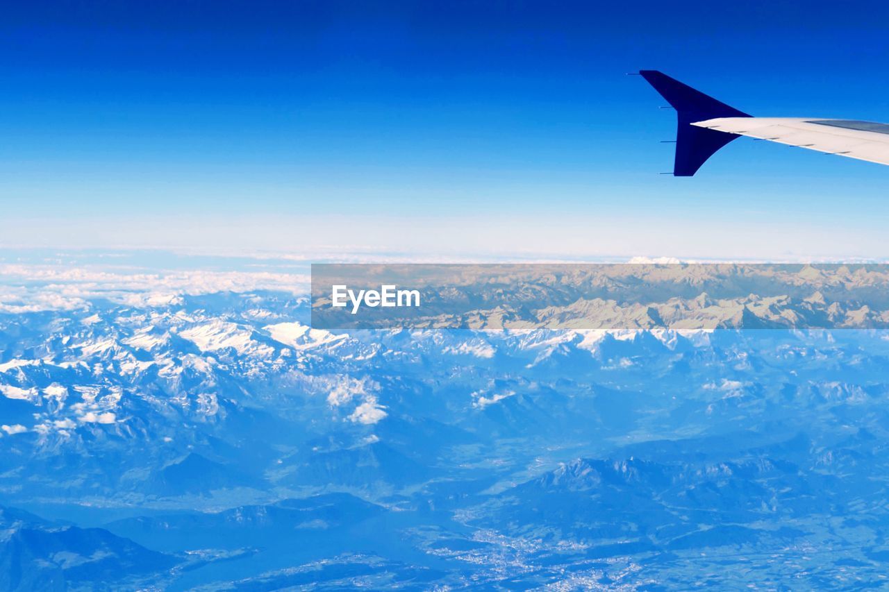 AERIAL VIEW OF SNOWCAPPED MOUNTAINS AGAINST SKY