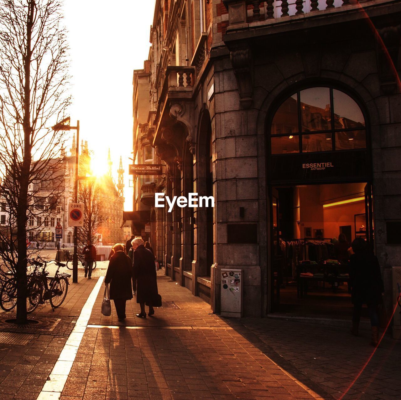 REAR VIEW OF MEN WALKING ON STREET IN CITY