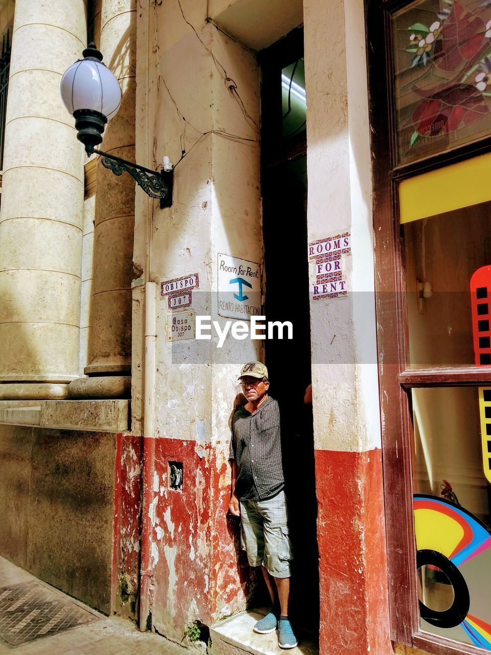 REAR VIEW OF MAN ON STREET AGAINST BUILDING