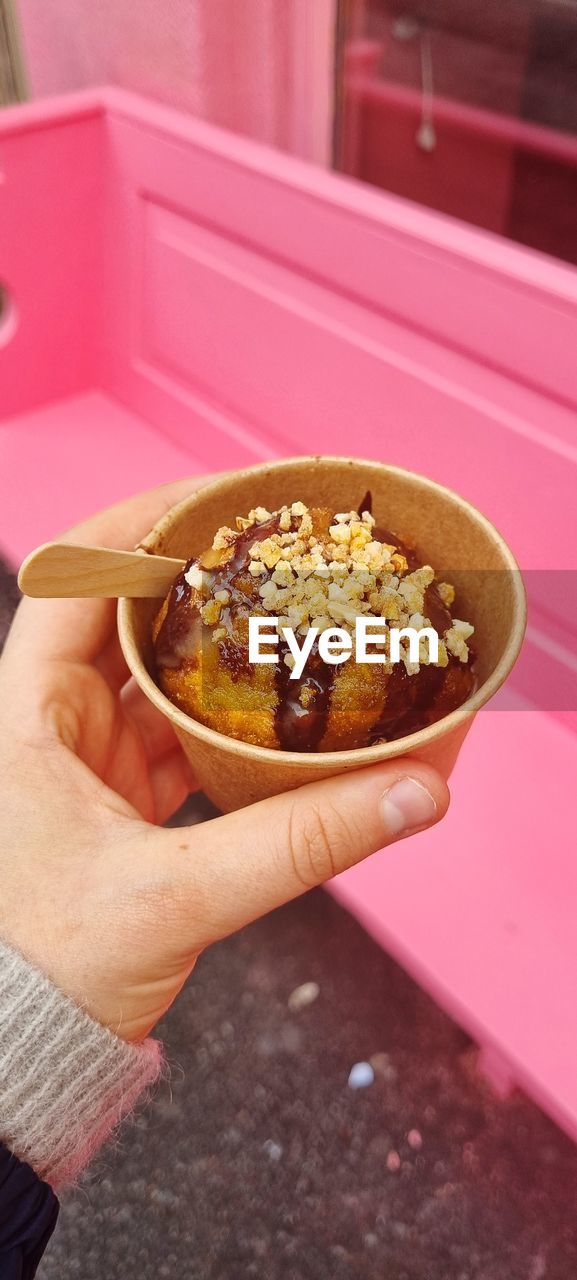 CLOSE-UP OF HAND HOLDING CHOCOLATE CAKE