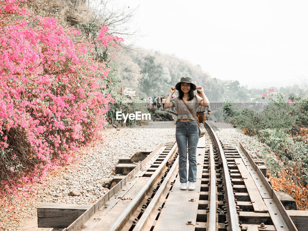 Portrait of young woman standing on railroad track