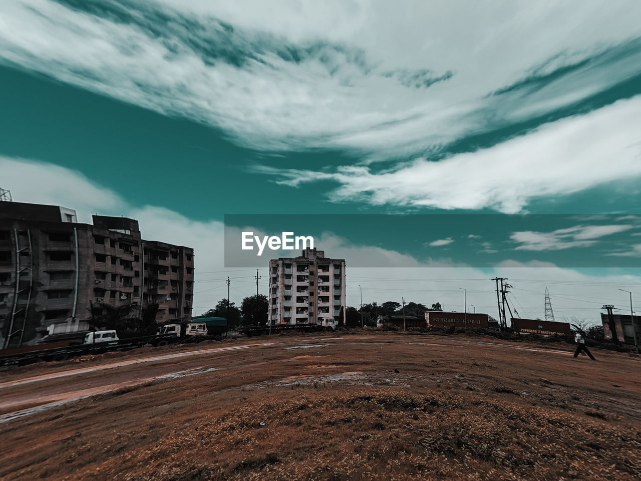 ROAD AMIDST BUILDINGS AGAINST SKY