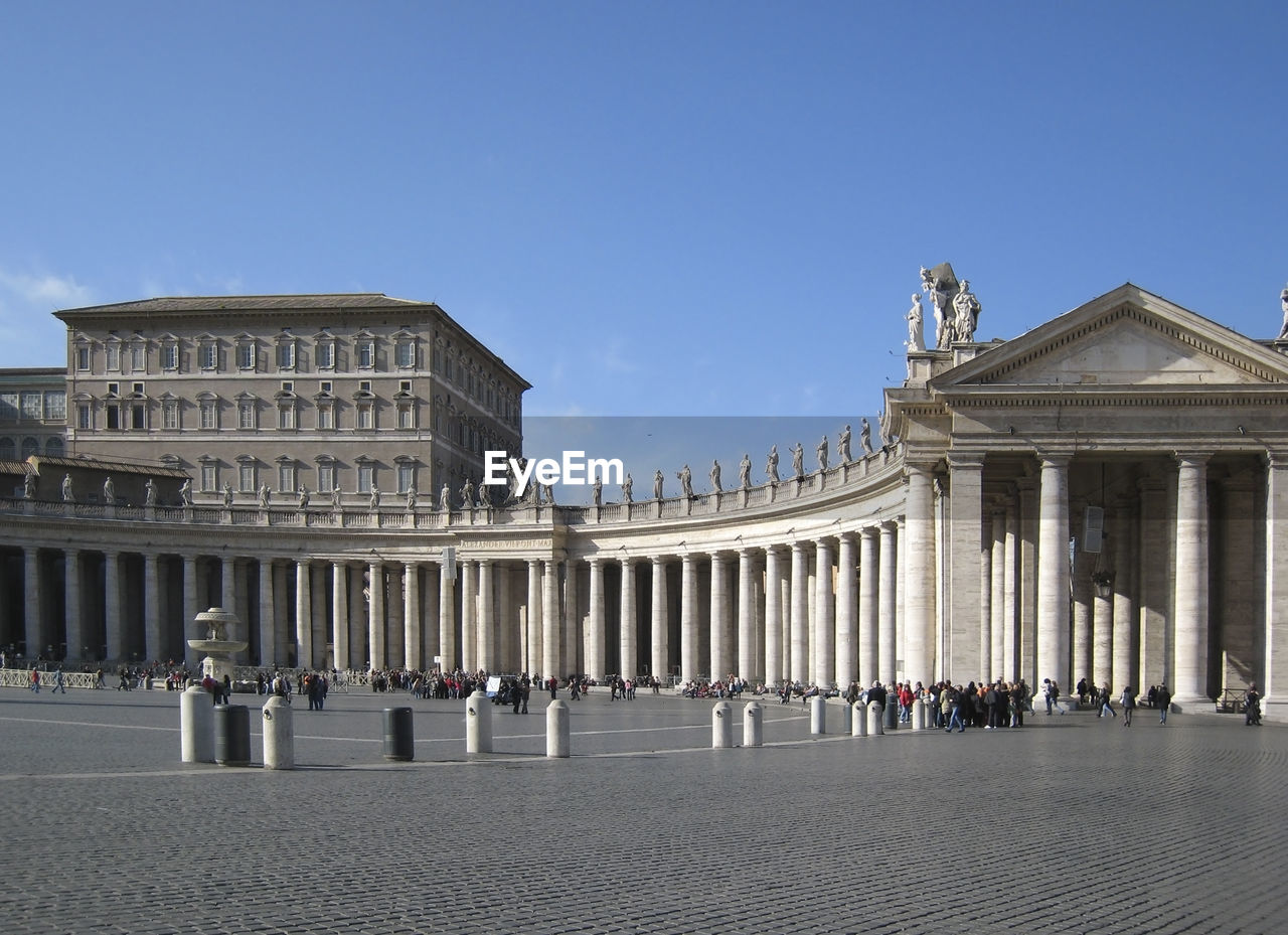 GROUP OF PEOPLE IN FRONT OF HISTORICAL BUILDING AGAINST SKY