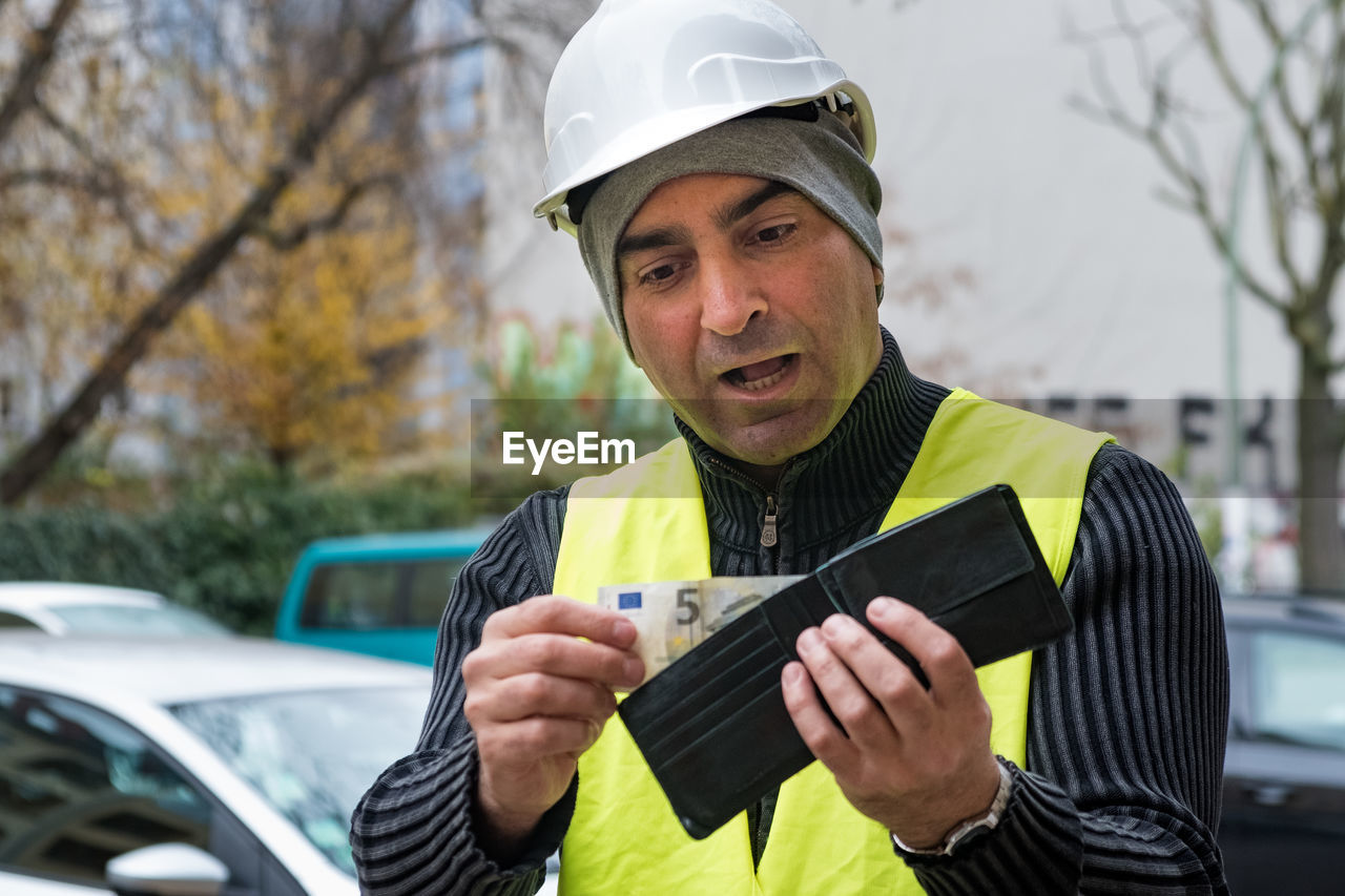 Engineer in reflective clothing looking at wallet