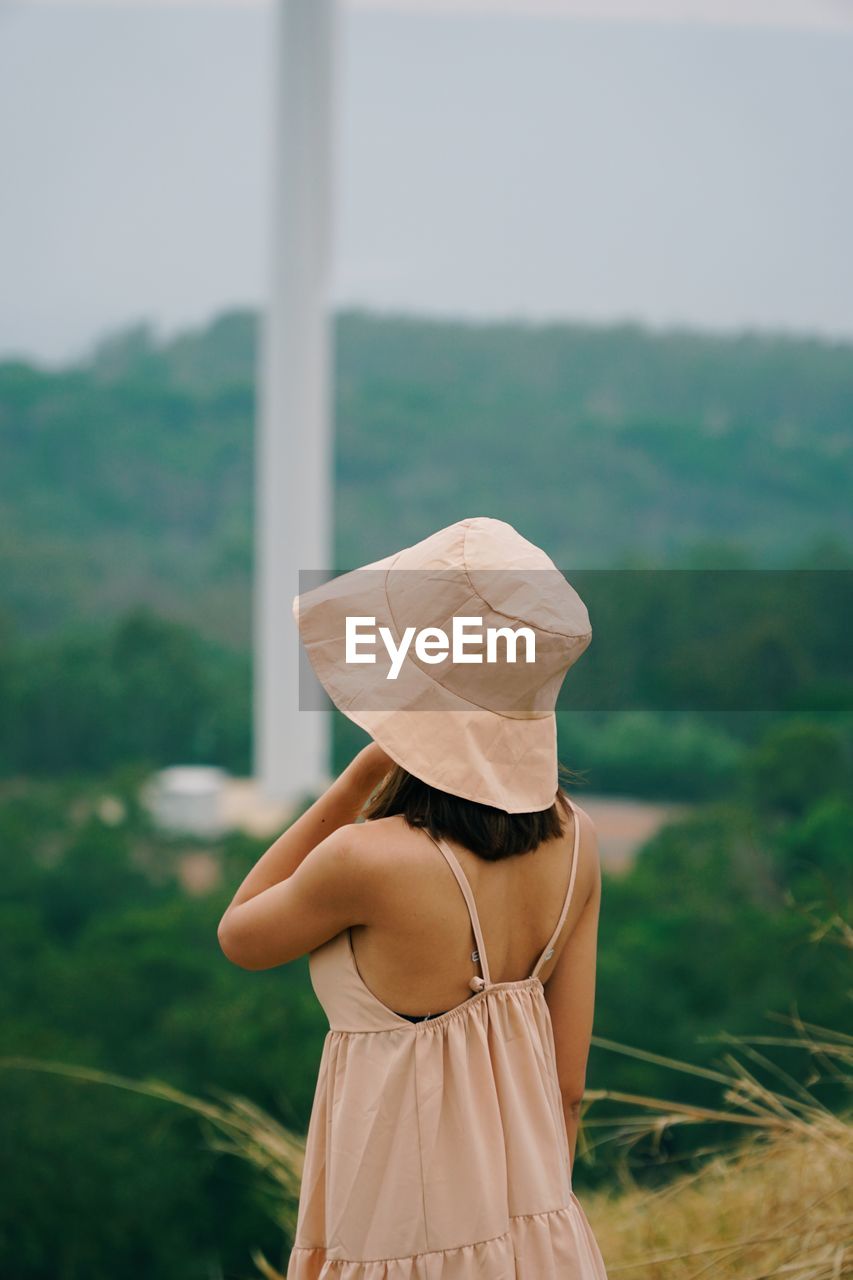 Rear view of woman wearing hat standing outdoors