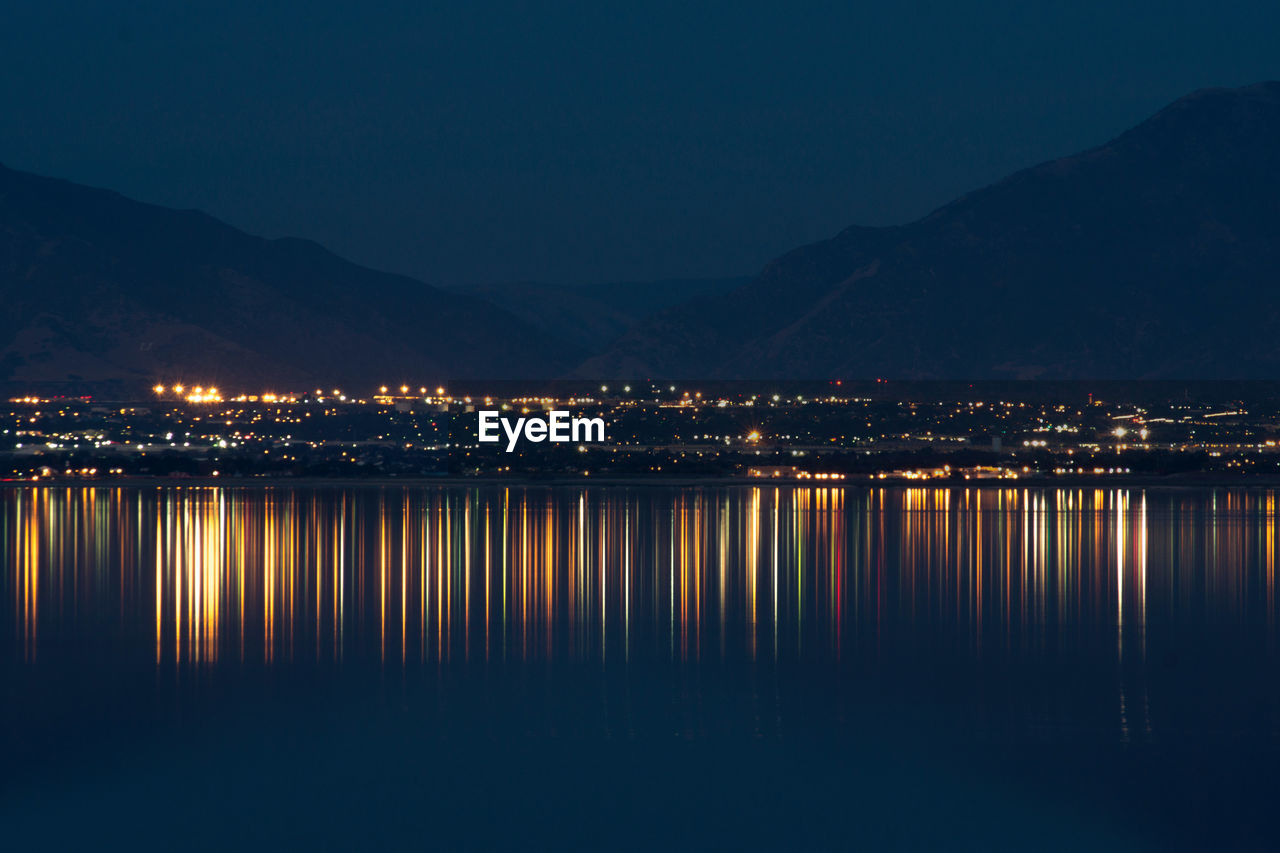 Reflection of illuminated buildings in lake at night