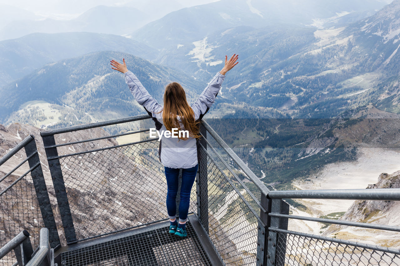 Young girl enjoys the views of the alps from the observation deck