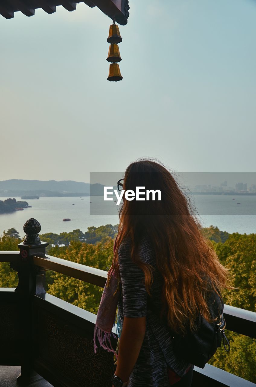 Woman looking at view while standing on balcony