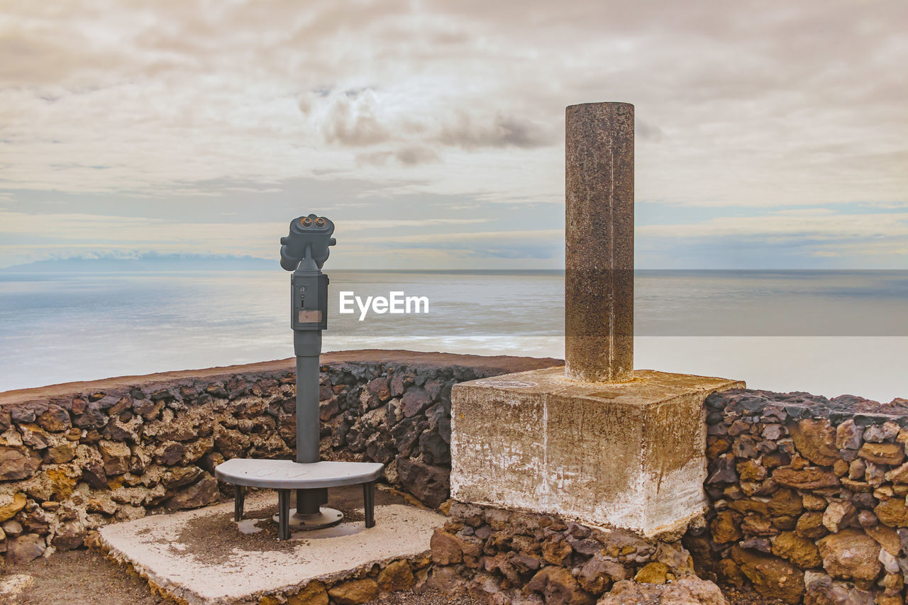 LIFEGUARD HUT ON WOODEN POST AGAINST SKY