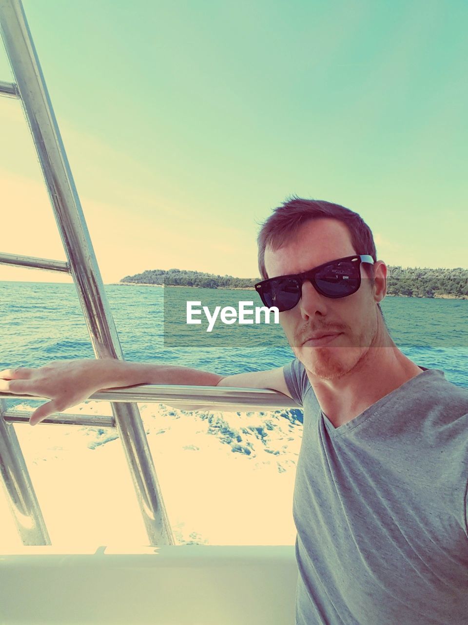 Portrait of man wearing sunglasses in boat sailing on sea