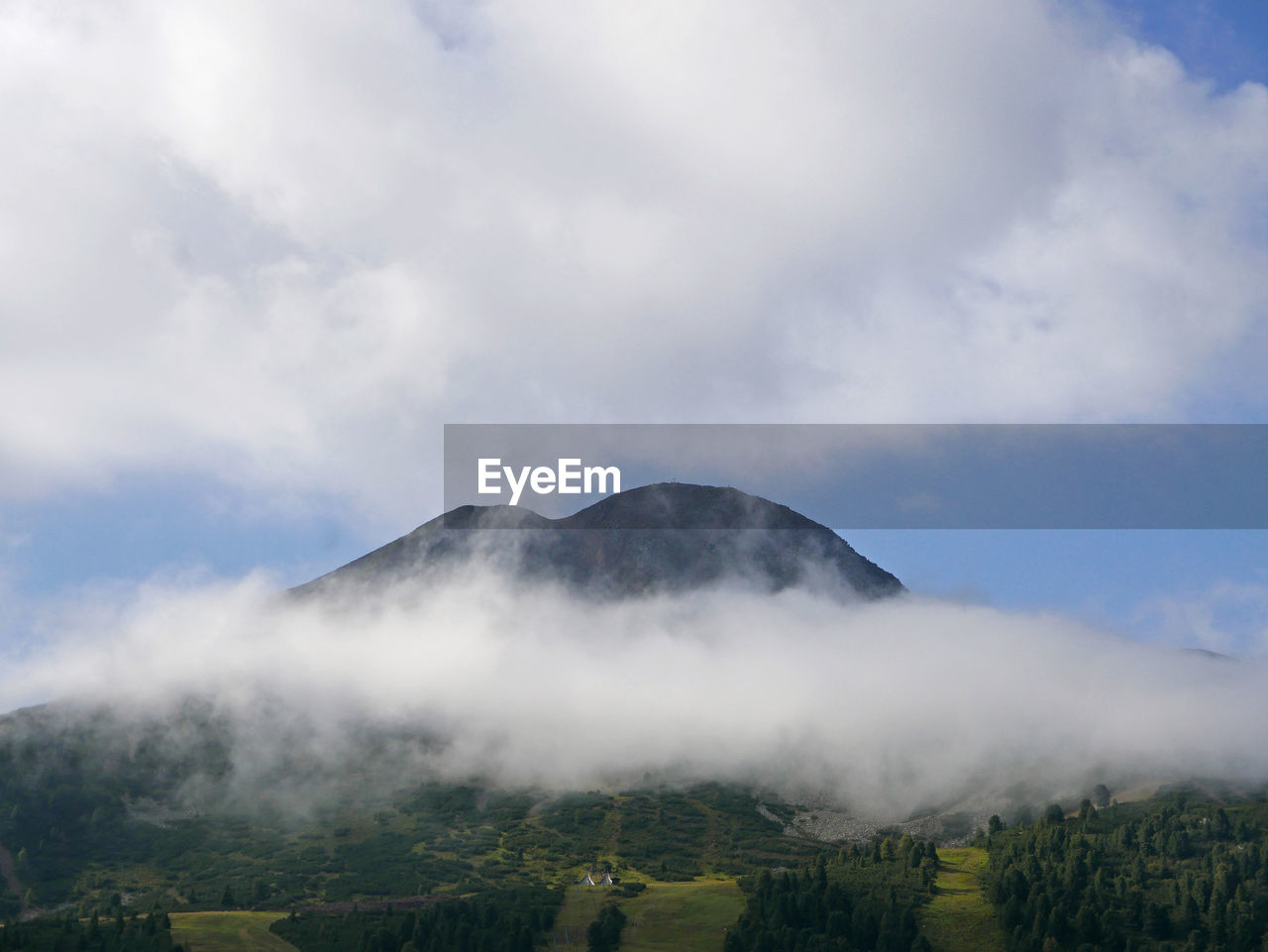 Evocative image of a mountain peak shrouded in fog