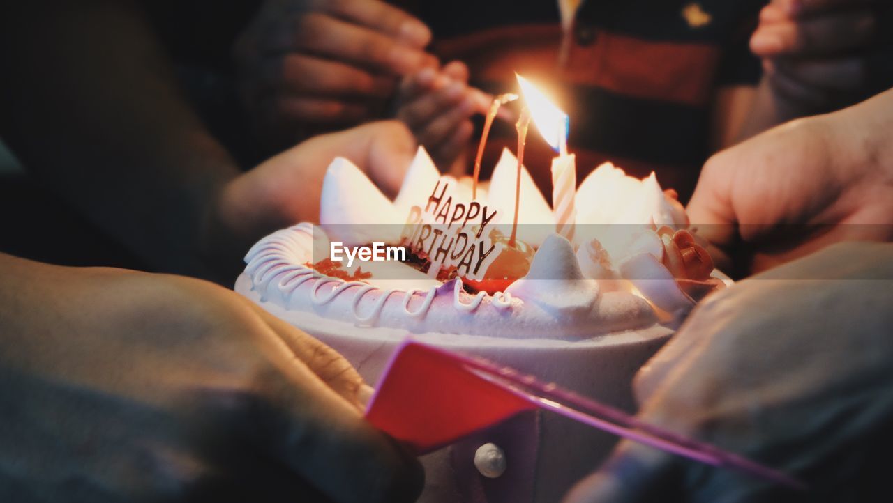 Close-up of hand holding birthday cake