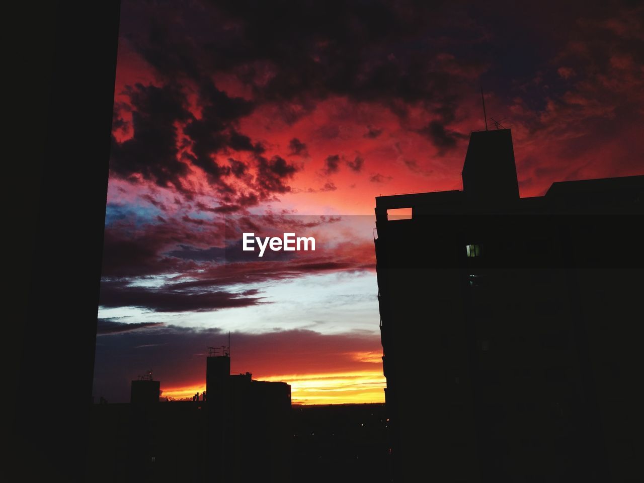 SILHOUETTE BUILDINGS AGAINST CLOUDY SKY DURING SUNSET