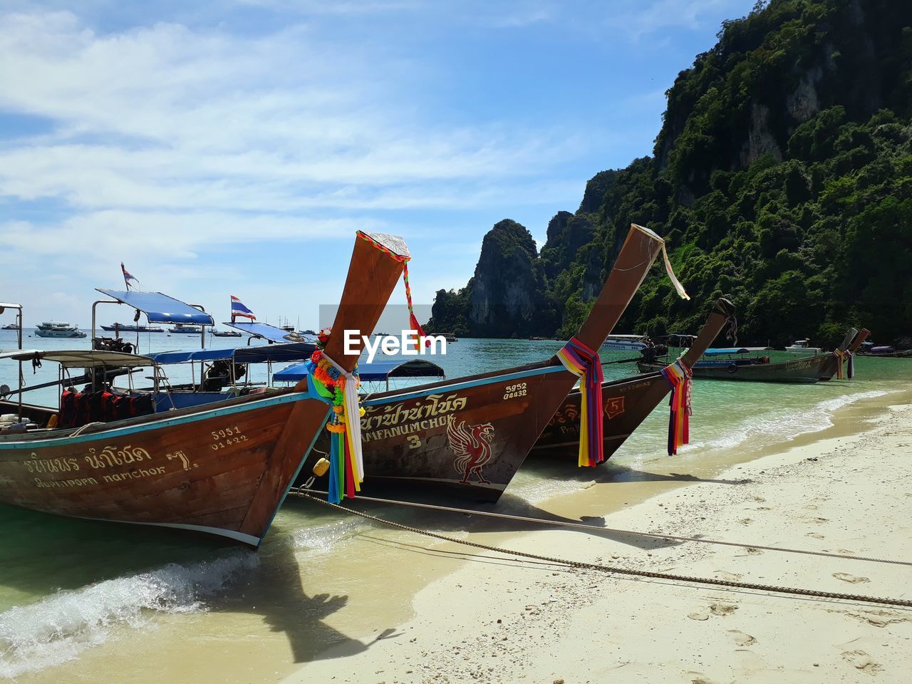 Boat moored on beach against sky