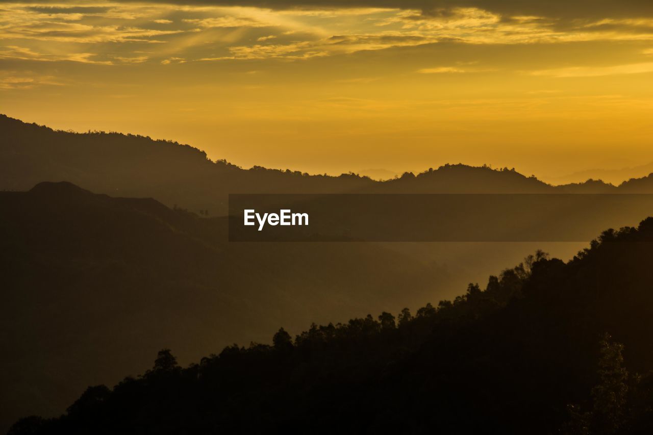 Scenic view of silhouette mountains against sky at sunset