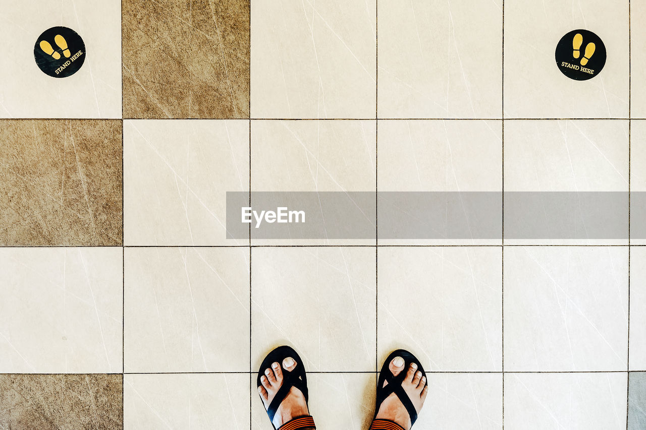 Low section of woman standing on tiled floor