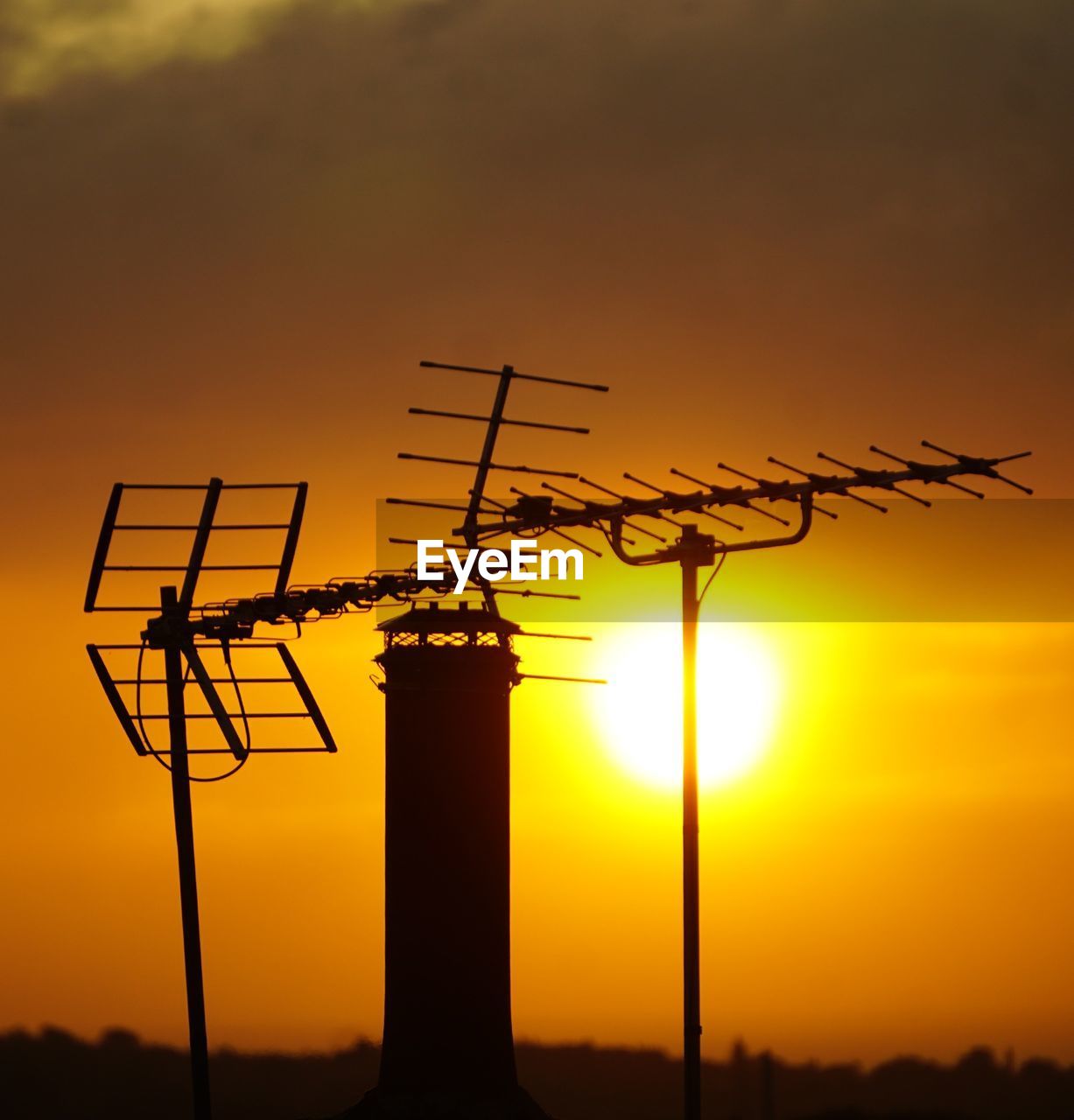 sunset, sky, silhouette, orange color, technology, electricity, nature, afterglow, no people, dawn, yellow, architecture, line, sun, environment, communication, outdoors, built structure, sunlight, power generation, evening, cloud, dramatic sky, beauty in nature, television antenna, twilight, wind, back lit, industry, landscape