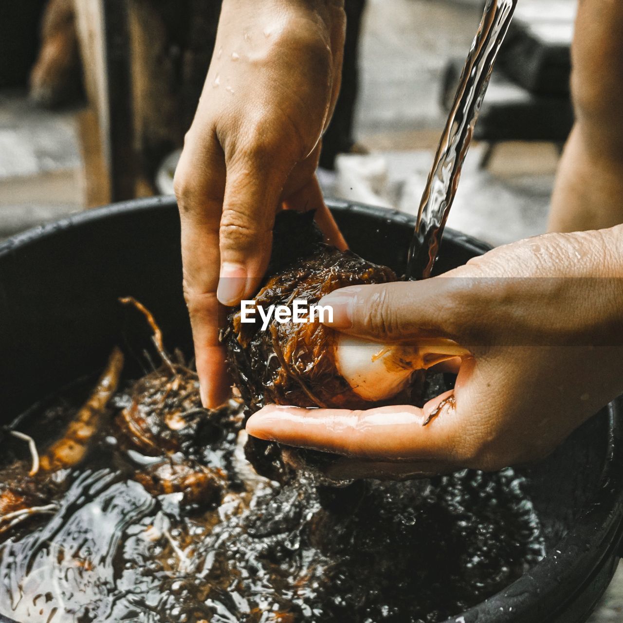 Close-up of person washing food in running water