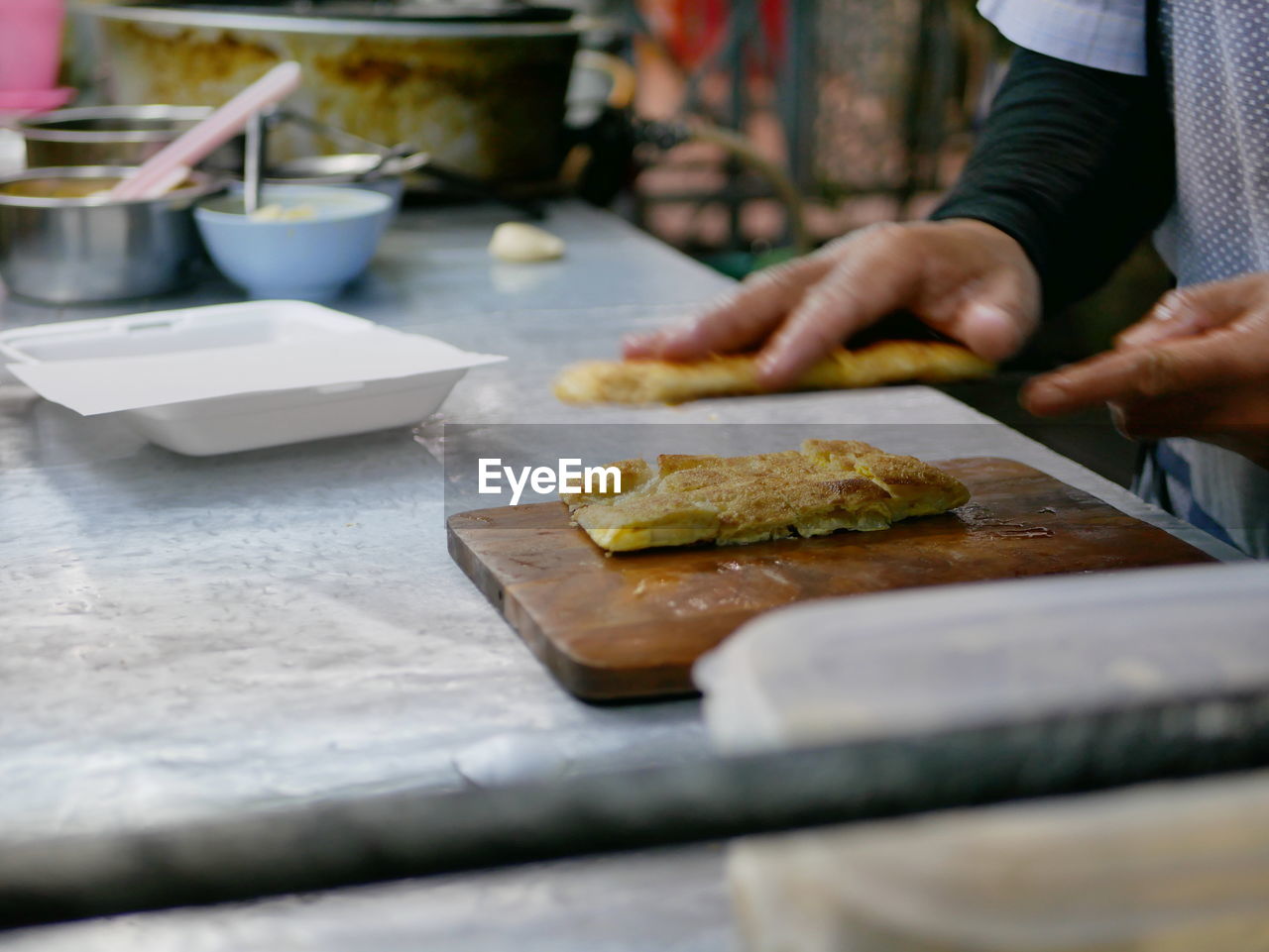 Crisp chopped roti being put in a box getting ready to be served - delicious street food in thailand