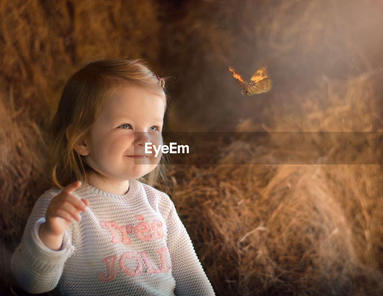 Cute girl smiling while looking at butterfly