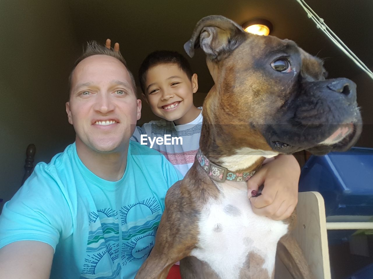 Portrait of smiling man with son and dog at home