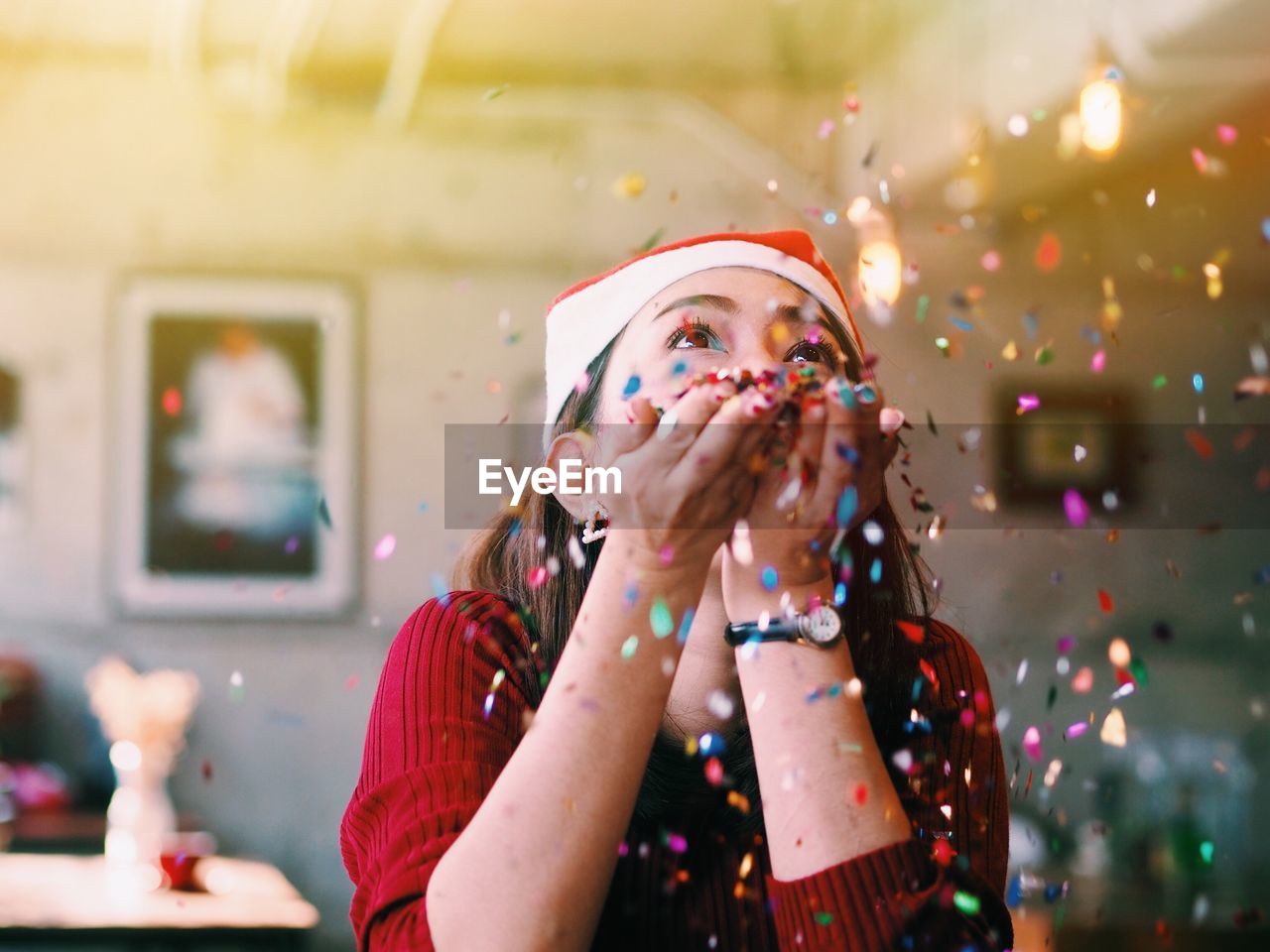 Close-up of young woman blowing confetti