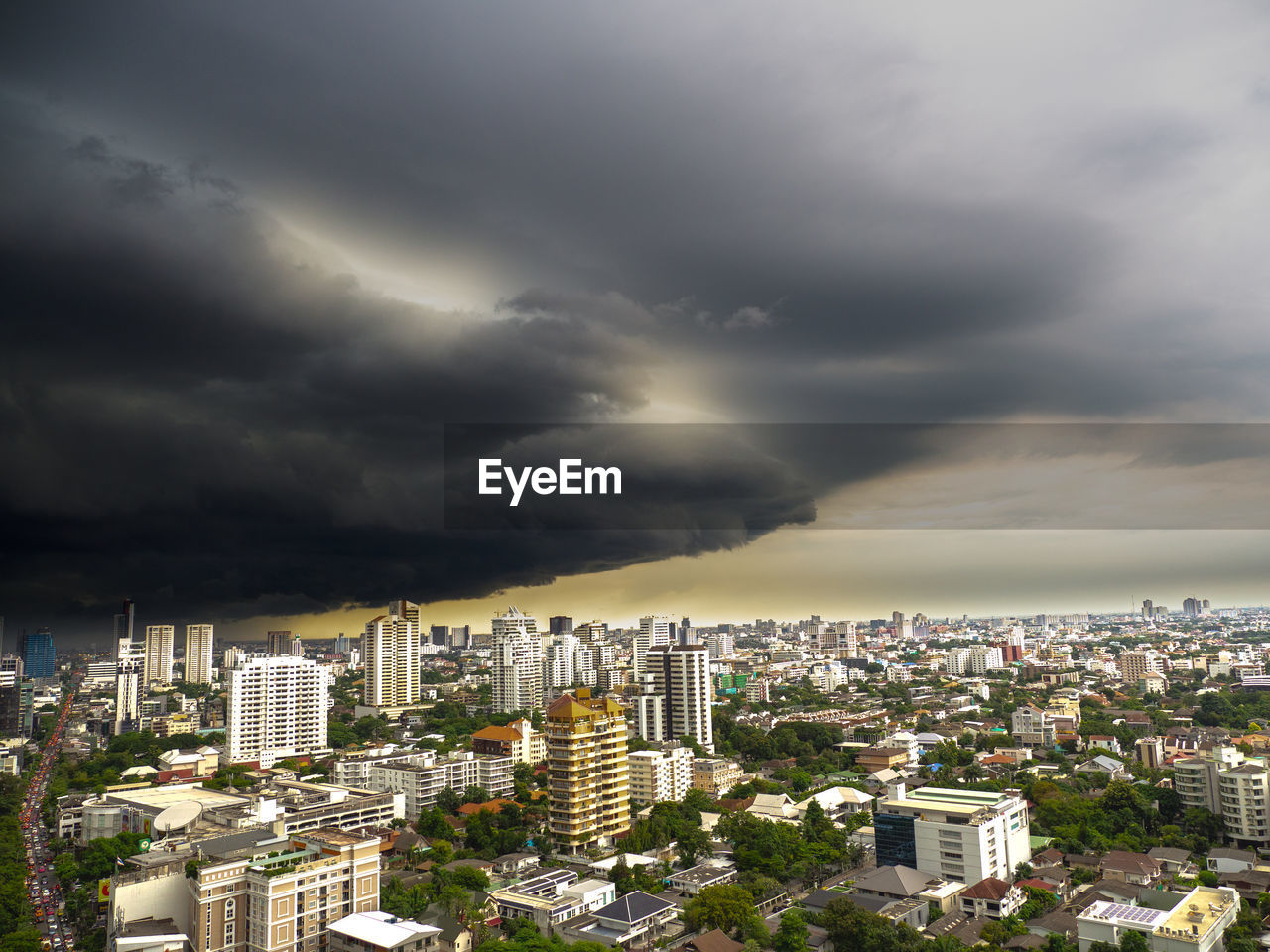 HIGH ANGLE VIEW OF CITY BUILDINGS AGAINST STORM CLOUDS
