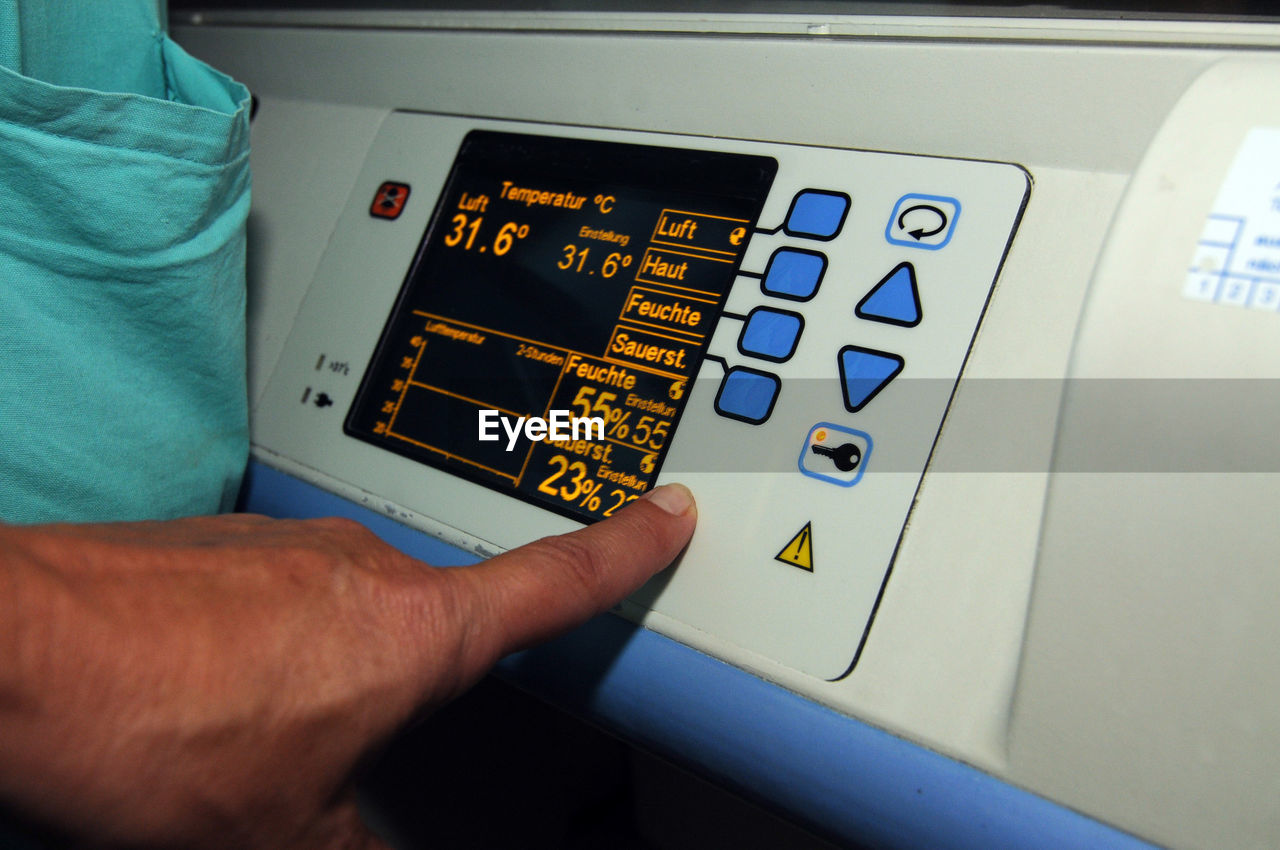 Cropped hand of man touching medical instrument