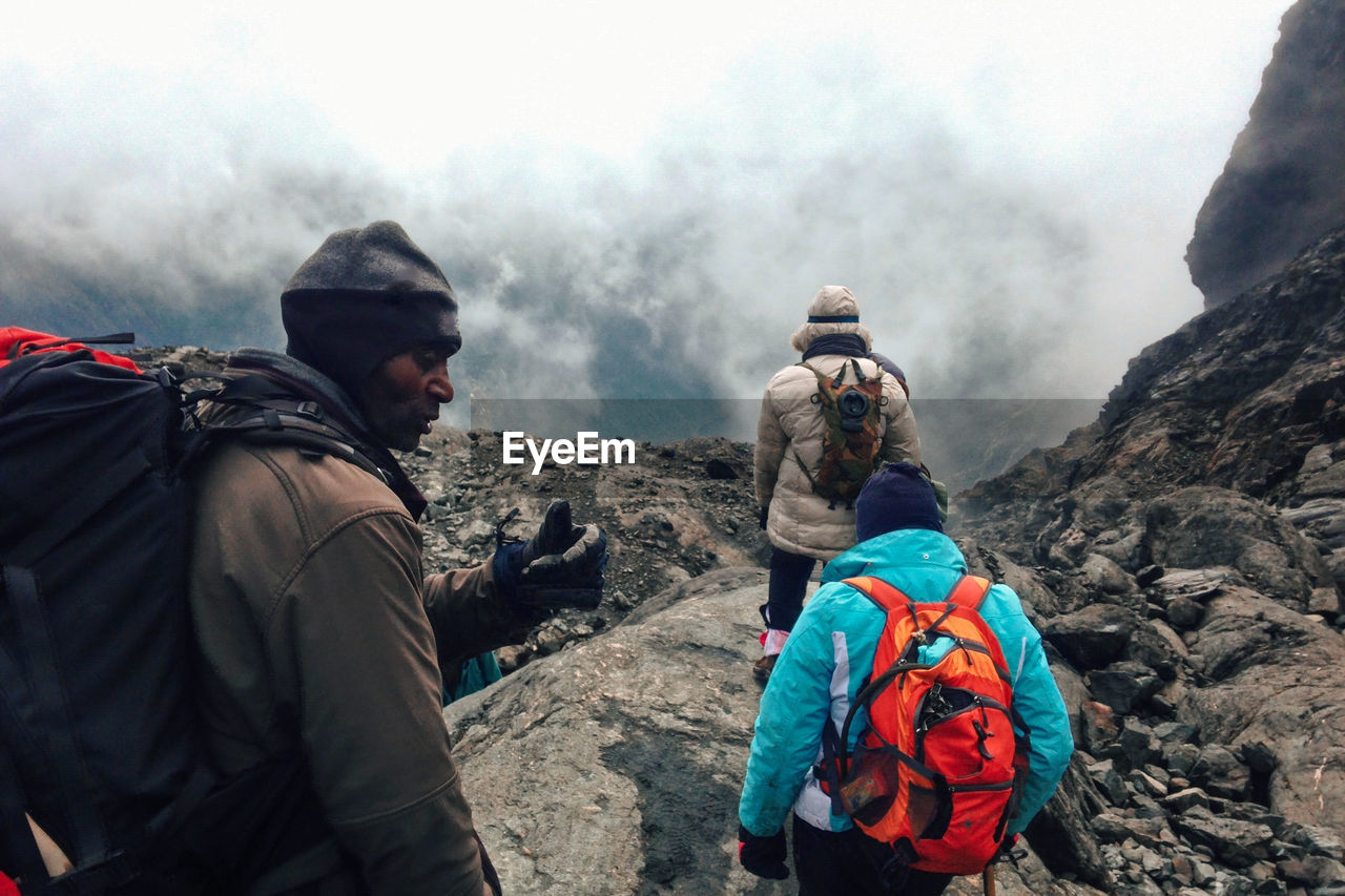 A group of hikers in the panoramic mountain landscapes of rwenzori mountains, uganda