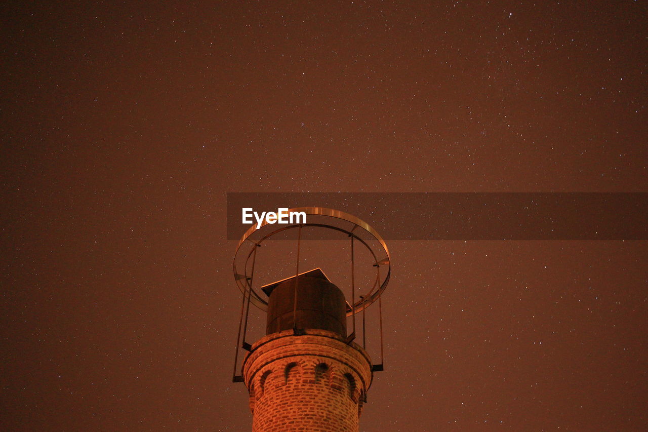 Low angle view of water tower against sky at night