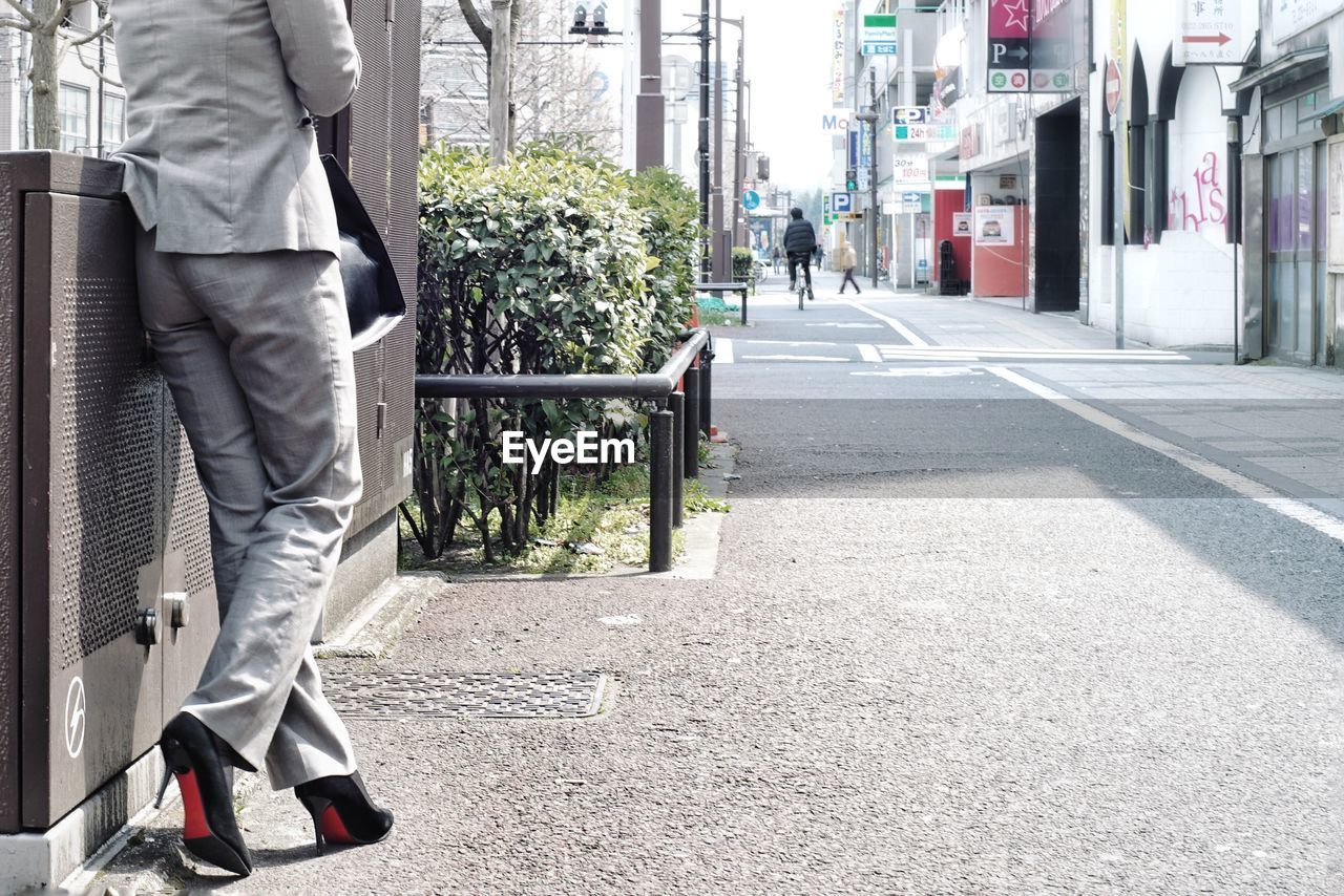 Low section of women walking in city