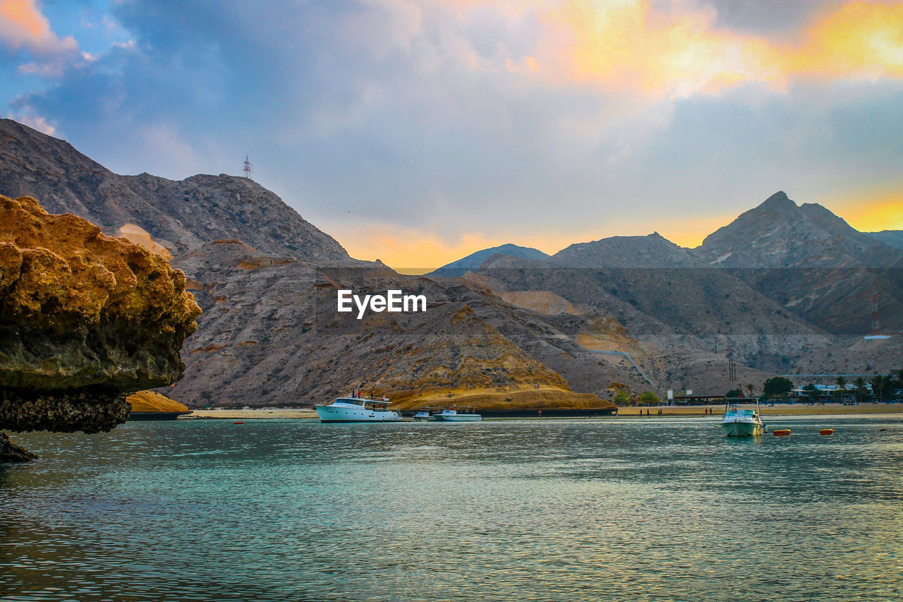 Scenic view of a cove and mountains against sky during sunset