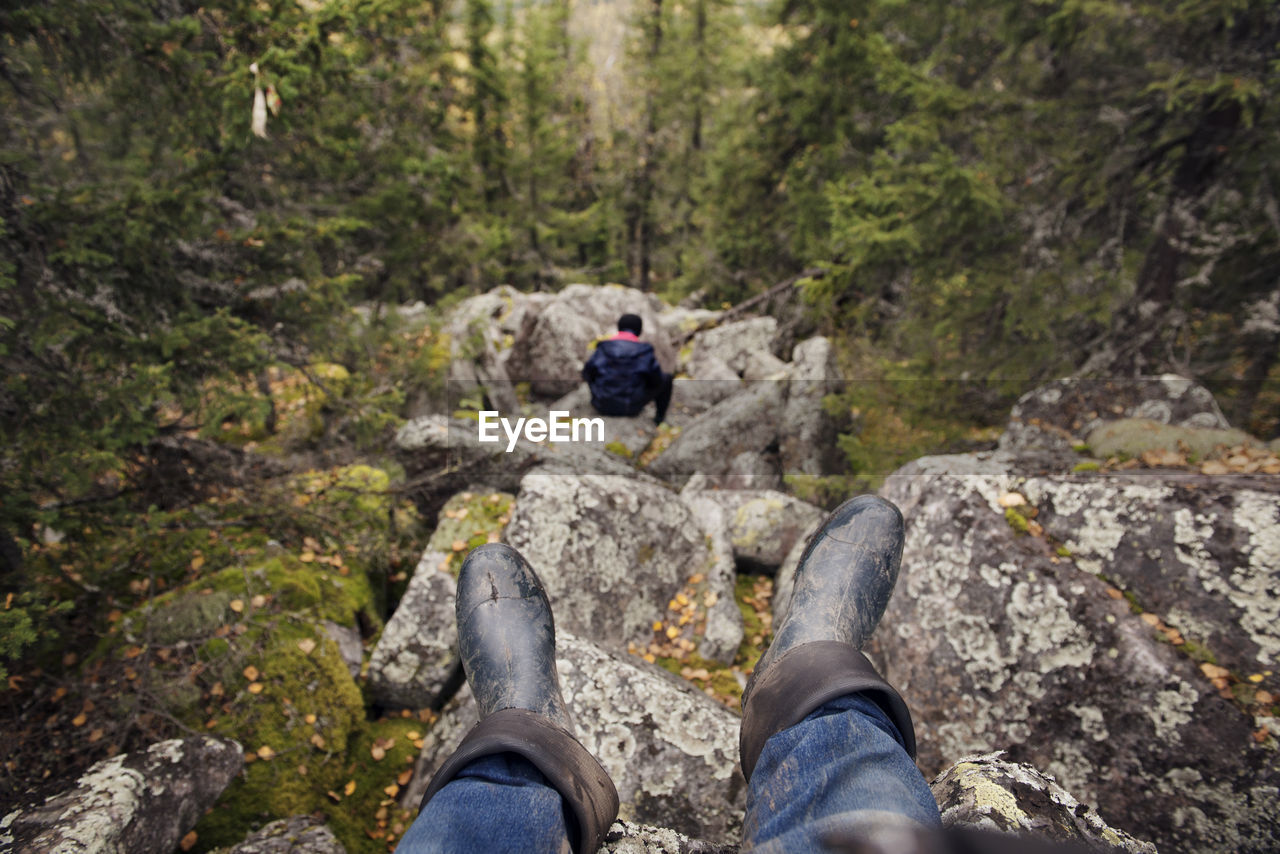 Hiker sitting on rocks in forest