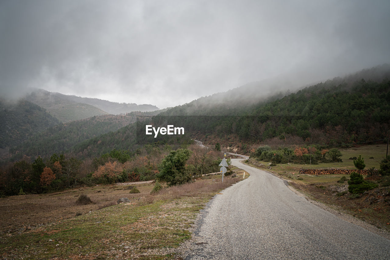 Road leading towards mountains against sky