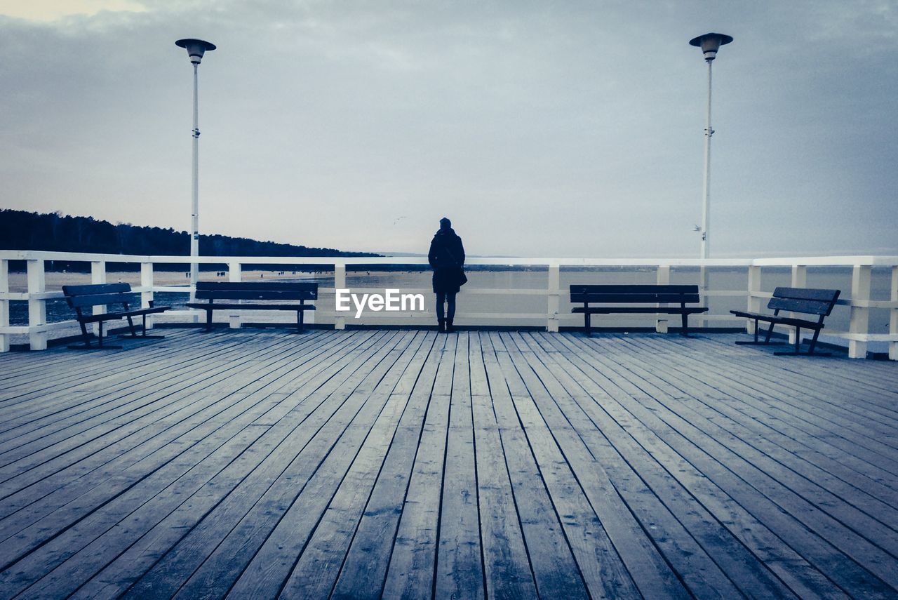 Woman standing on wooden pier
