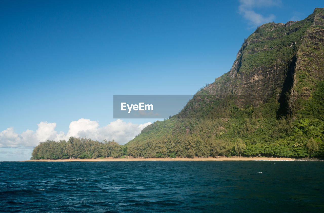 Scenic view of sea and mountains against sky